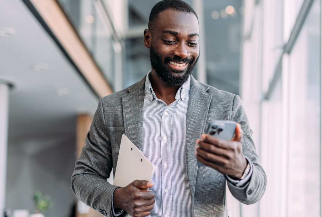 Confident businessman reading company news on smartphone